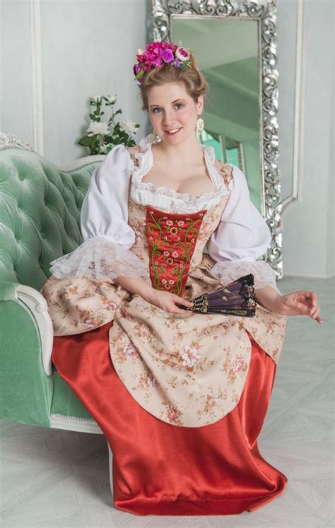 Beautiful Woman In Old Fashioned Medieval Dress On The Sofa Stock Photo