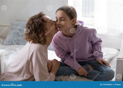 loving mother kissing adorable teenage pretty daughter on cheek stock image image of enjoy
