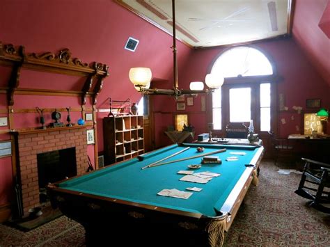 A Pool Table Is In The Middle Of A Room That Has Pink Walls And An