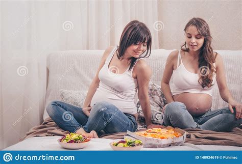 Two Pregnant Women Eating Pizza And Salad At Home Stock Image Image