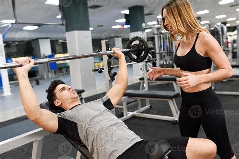 Female Personal Trainer Motivating A Young Man Lift Weights 4675860