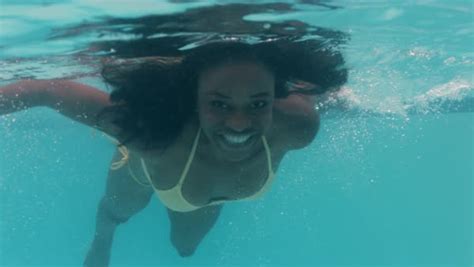 Beautiful African American Woman Swimming Underwater In Pool Smiling Floating In Blue Crystal