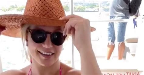 britney spears tells fans to calm down as she strips topless and poses in thong bikini daily