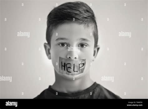 Sad Little Boy With Taped Mouth And Word Help On Grey Background