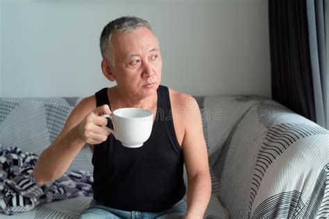 Portrait Of Mature Japanese Man Drinking Coffee And Thinking In The Living Room Stock Image