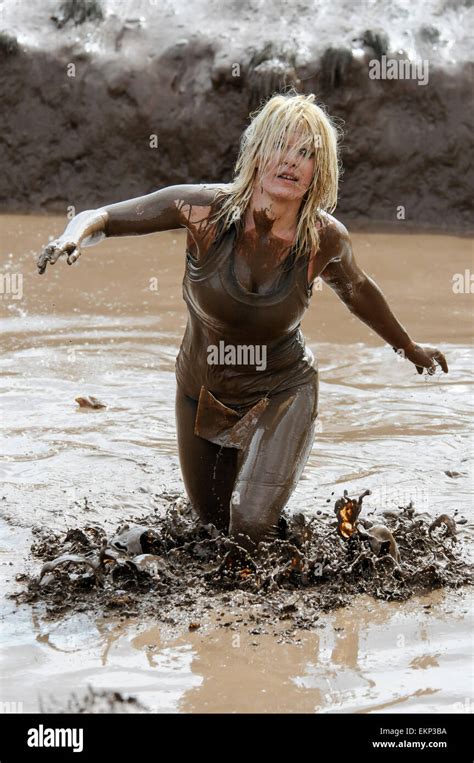 Mid 20s 30s Blonde Woman Emerges From Mud Pool At Finish Line Of An