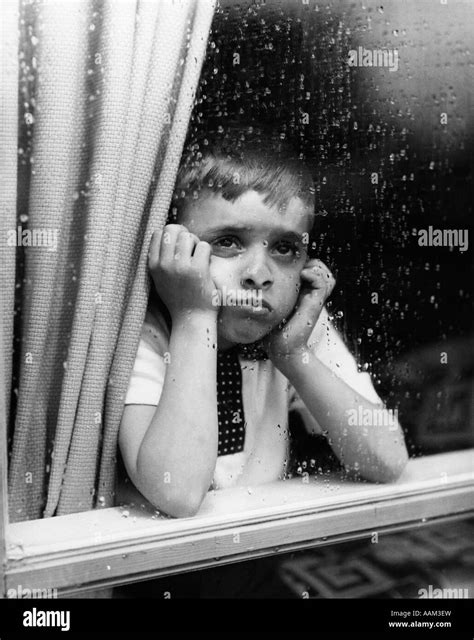 1950s Sad Boy Looking Outside Through Rainy Window Stock Photo Alamy