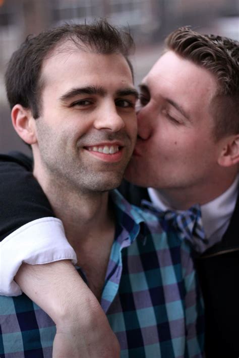 Two Men Are Kissing Each Other While One Is Wearing A Blue And White Checkered Shirt