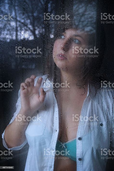 Woman Looking Through Window With Raindrops Stock Photo Download
