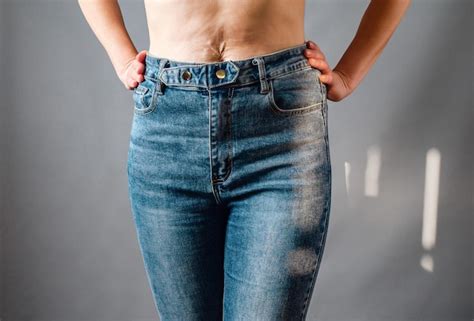 Premium Photo Slender Female Hips In Blue Jeans Hands On Hips Stretch Marks On The Skin Of