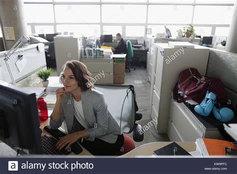 Focused Businesswoman Working At Computer In Cubicle With Boxing Gloves