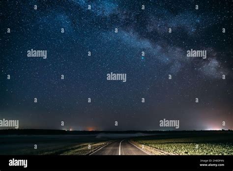 Blue Night Starry Sky Above Country Asphalt Road In Countryside And