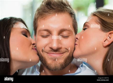 Women Kissing Smiling Mans Cheeks Stock Photo Alamy