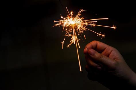 A Hand Holding A Sparkler In The Dark