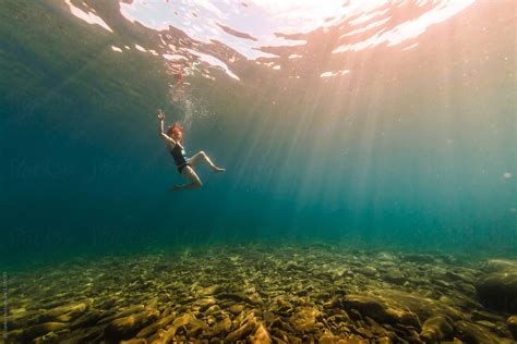 woman swimming underwater in crystal clear summer lake by stocksy contributor jp danko stocksy
