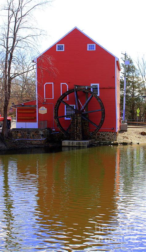 Reflection Of The Grist Mill Waterwheel In The Historic Town Of