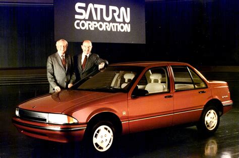 General Motors executives proudly display an early Saturn prototype