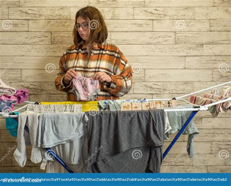 a woman hangs up wet clothes after washing on the dryer stock image image of comfortable