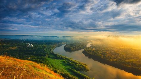 Aerial View Of Fog Covered Mountains Under Cloudy Sky And River Between