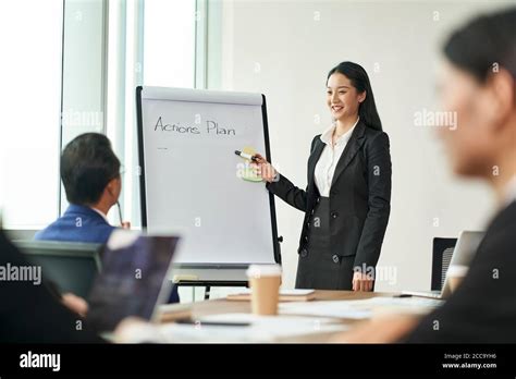 Young Asian Business Woman Presenting Actions Plans During Meeting With