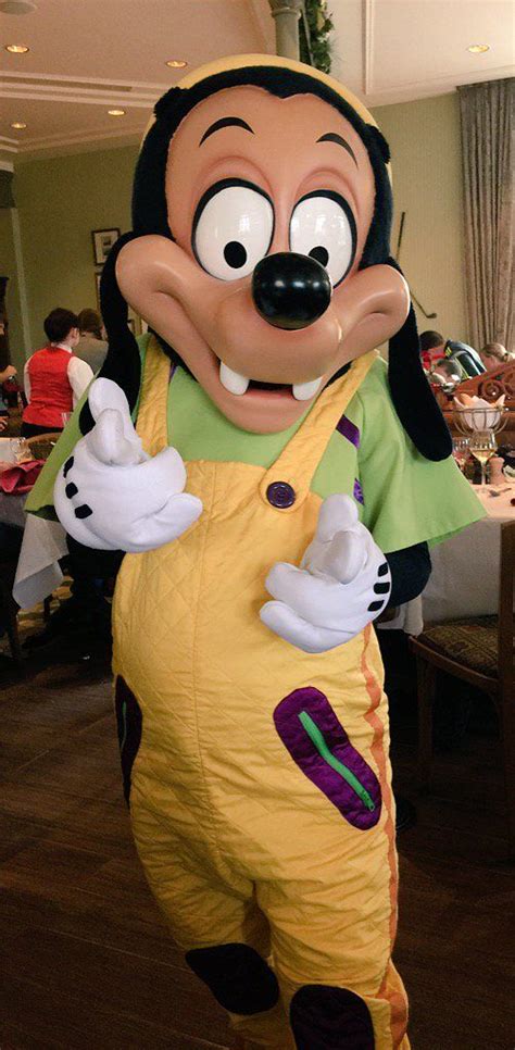 Goofy The Dog Mascot Standing In Front Of A Table
