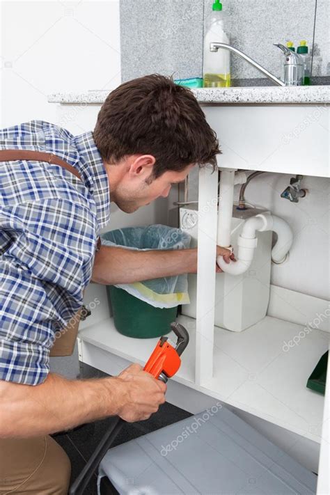 Plumber Fixing Sink In Kitchen Stock Photo By ©andreypopov 35620965