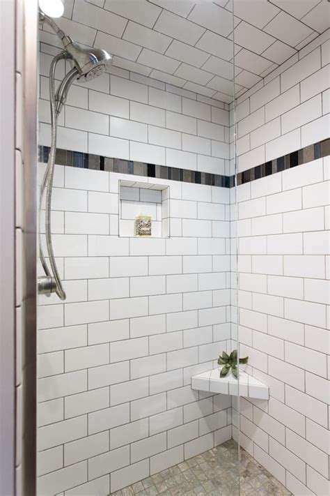 white subway tile shower with accent floor and dark tile accent strip bathroom shower tile