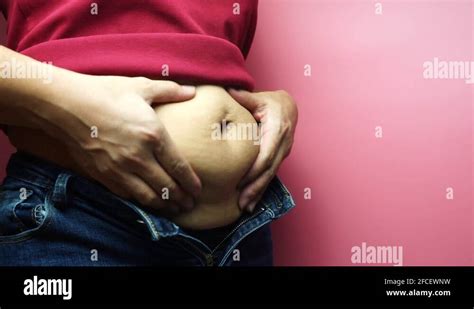 Overweight Fat Woman Touching Obese Belly Isolated On A Pink Background
