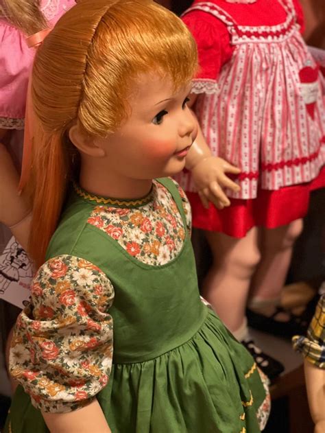 a close up of a doll with red hair