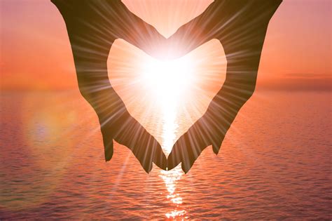 Two Hands In The Shape Of A Heart On A Sunset Background Over The Sea