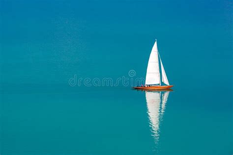 Sailing Boat On A Calm Lake With Reflection In The Water Serene Scenic