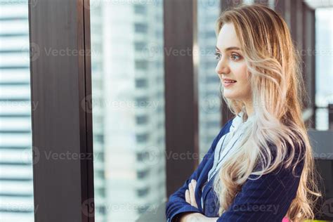 Caucasian Russian Business Woman Standing Looking Out Of Office Windows Smiling Good Mood