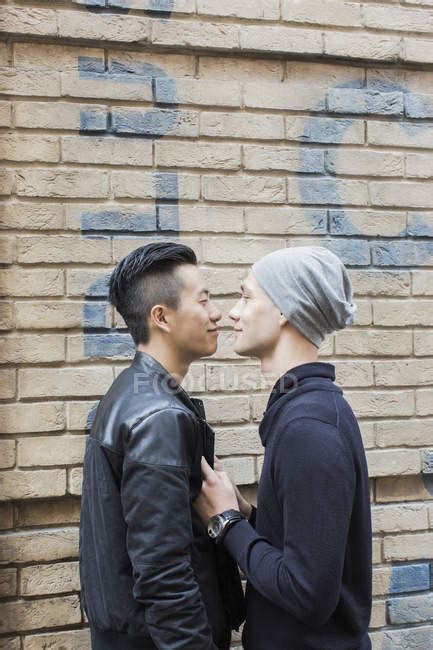 Gay Couple At House Wall Outdoors Cap Standing Stock Photo