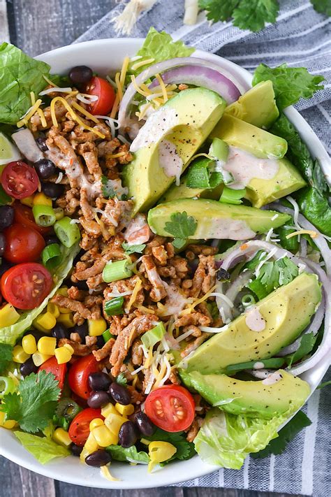 This hearty taco salad is made with a tasty ground beef and refried bean mixture. Loaded Taco Salad with Salsa Ranch Dressing - Mother Thyme