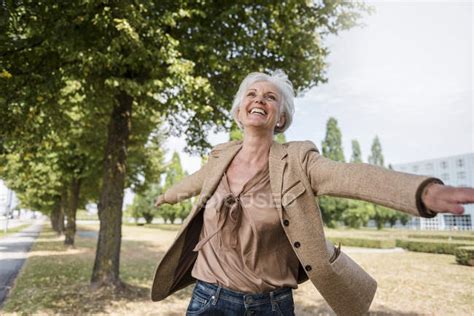 Happy Senior Woman With Outstretched Arms In Park — Portrait Nature