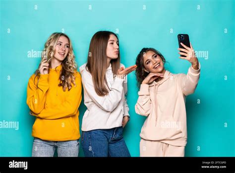 Young Three Multiethnic Girls Friends Take A Selfie By Camera Posing Over Turquoise Background