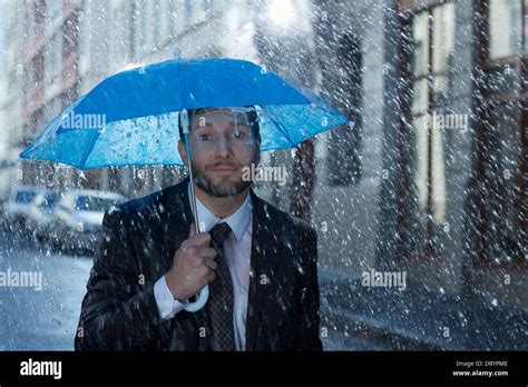 Portrait Of Businessman With Tiny Umbrella In Rain Stock Photo Alamy