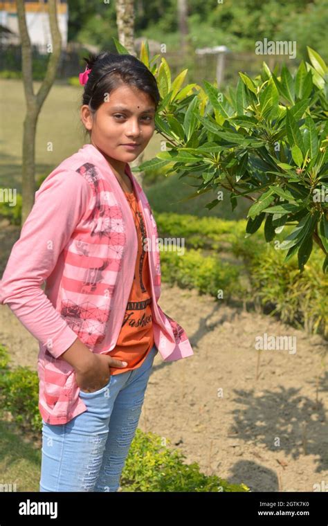 teenage indian bengali girl wearing jeans hands on pocket posing for photo in a garden stock