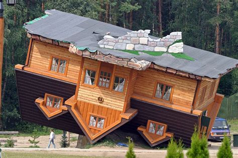An Upside Down Wooden House In The Middle Of A Forest With People