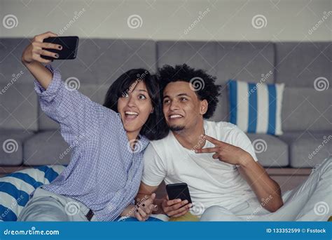 De Jeunes Couples De Sourire Prenant Des Selfies Dans Le Lit Utilisant
