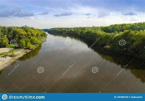 Track A Wide River With High Green Trees On The Banks Against The