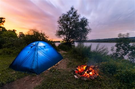 Premium Photo Tourist Tent Near The River Campfire Burning Low