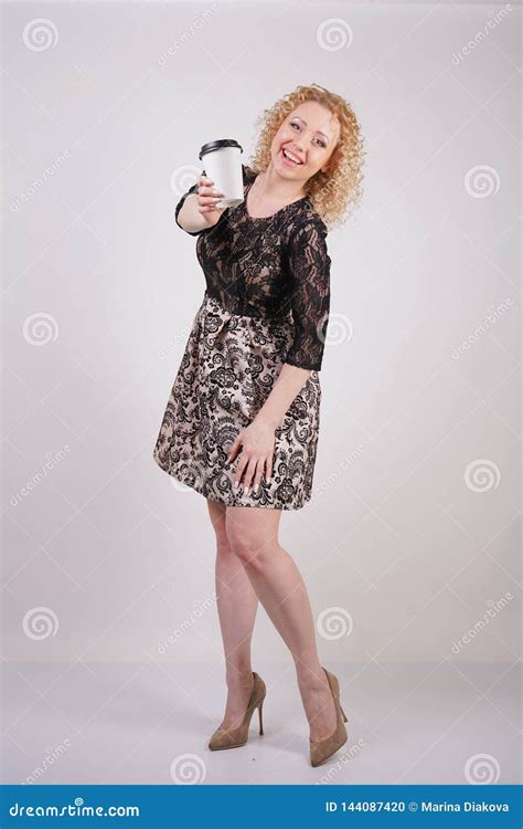 Cute Curly Blonde Girl Stands In Lace Short Evening Dress And Holds A