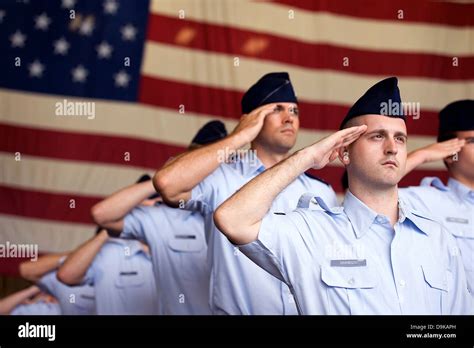 Us Air Force Airmen Salute To The American Flag During The Singing Of
