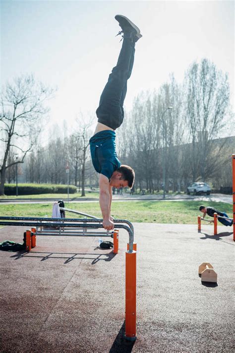 Calisthenics At Outdoor Gym Young Man Doing Handstand On Parallel Bars