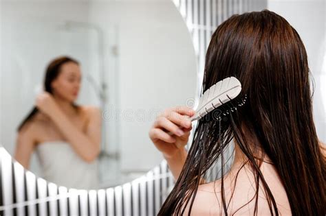 Attractive Woman In White Towel With Comb Brushing Her Wet Hair After