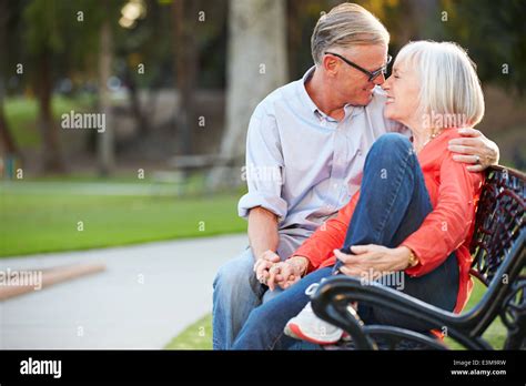 Mature Romantic Couple Sitting On Park Bench Together Stock Photo Alamy
