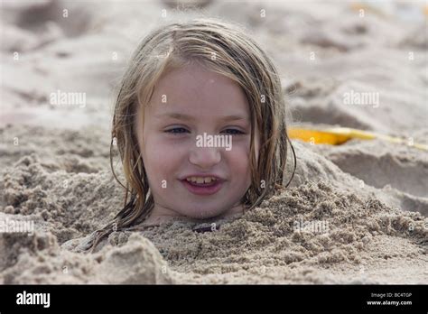 Junge Mädchen Bis Zum Kopf Im Sand Am Strand Stockfotografie Alamy