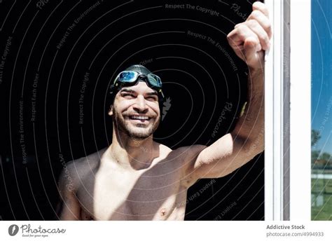 Happy Muscular Swimmer With Naked Torso Behind Window In Sunlight A