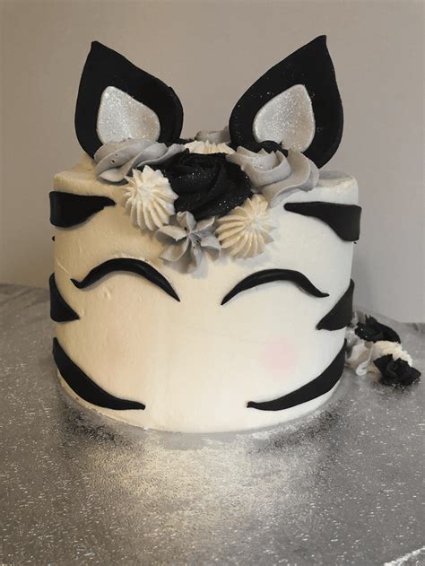 a close up of a cake with black and white decorations on it s face